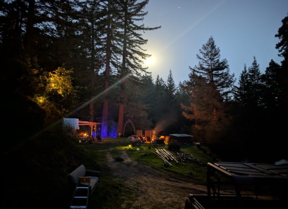 Moonrise over the lit camp